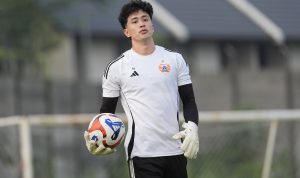 cyrus-margono-kiper-baru-java-united.webp Cyrus Margono mengenakan sarung tangan dan memegang bola dalam sesi latihan.