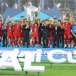 vietnam-tulis-sejarah-baru-sejajar-singapura-4-trofi-piala-aff.webp Para pemain tim nasional Vietnam mengangkat trofi juara Piala AFF saat merayakan kemenangan di atas panggung.