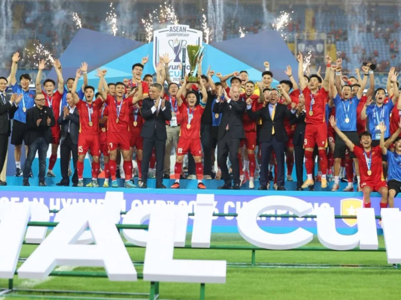 Para pemain tim nasional Vietnam mengangkat trofi juara Piala AFF saat merayakan kemenangan di atas panggung.