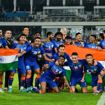 timnas-india-mundur-fifa-asean-cup-2026-selebrasi.webp Pemain dan staf Timnas India merayakan kemenangan bersama sambil membentangkan bendera nasional India di lapangan sepak bola