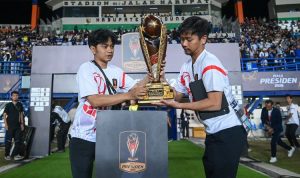 Petugas membawa dan meletakkan trofi resmi Piala Presiden di Stadion Si Jalak Harupat menjelang laga Semifinal Piala Presiden 2026.