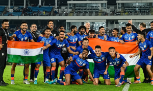 Pemain dan staf Timnas India merayakan kemenangan bersama sambil membentangkan bendera nasional India di lapangan sepak bola
