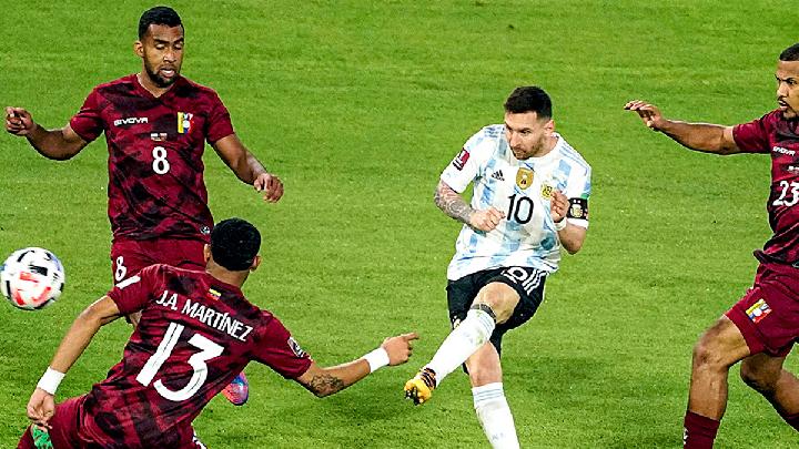 Lionel Messi menggiring bola melewati kepungan tiga pemain Venezuela dalam pertandingan Timnas Argentina.