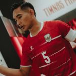 Bek Timnas Indonesia Rizky Ridho dengan nomor punggung 5 berjalan di ruang ganti pemain.
