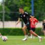 Alexander Jeremejeff mengenakan jersey latihan hitam Persija Jakarta saat mengontrol bola di lapangan.