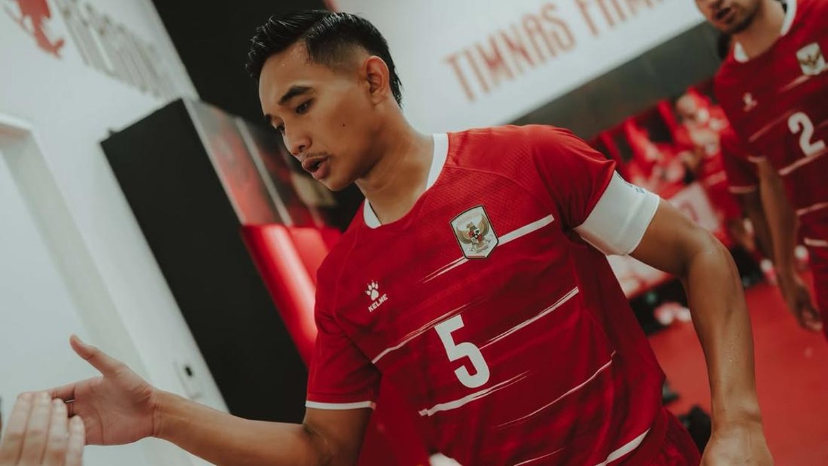 Bek Timnas Indonesia Rizky Ridho dengan nomor punggung 5 berjalan di ruang ganti pemain.