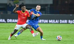 Marc Klok dari Persib Bandung berebut bola secara sengit dengan pemain lawan di lapangan.