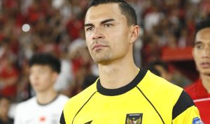 Emil Audero mengenakan jersey kiper Timnas Indonesia berwarna kuning di lapangan.