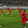 Para pemain Timnas Indonesia mengenakan jersey merah sedang berlatih lari di lapangan stadion jelang laga ASEAN Cup 2026.