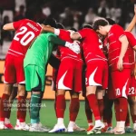jadwal-tayang-timnas-indonesia-vs-malaysia.webp Skuad Timnas Indonesia saling merangkul dalam lingkaran huddle sebelum kick-off melawan Malaysia.