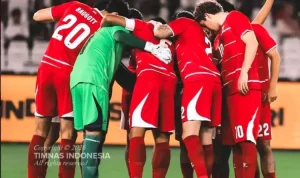 Skuad Timnas Indonesia saling merangkul dalam lingkaran huddle sebelum kick-off melawan Malaysia.