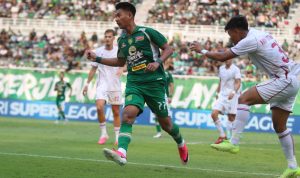 Akselerasi pemain Persebaya Surabaya nomor punggung 77 saat melepaskan diri dari kawalan bek lawan dalam laga yang berakhir imbang di menit akhir.