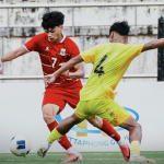 Timnas Indonesia U20 sedang berebut bola dengan pemain Malaysia dalam pertandingan sengit.