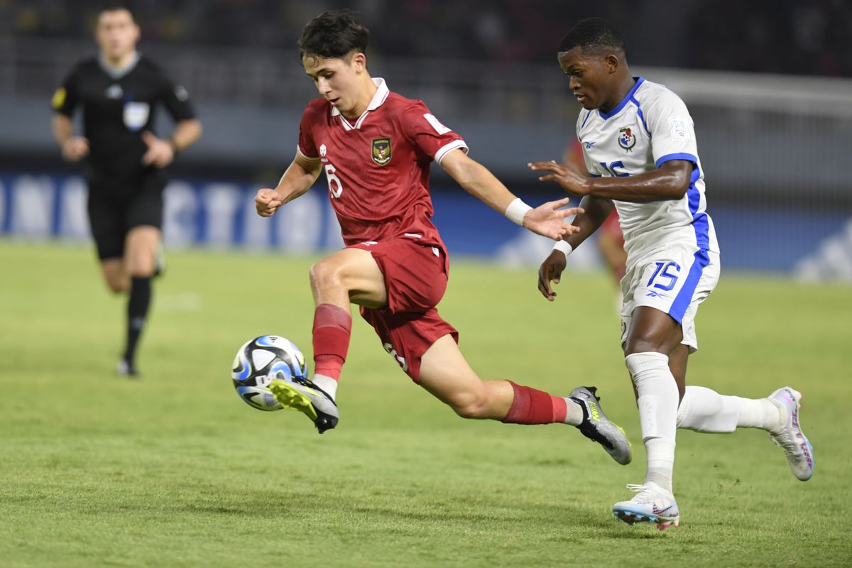 Amar Brkic mengontrol bola saat membela Timnas Indonesia U-17 menghadapi pemain lawan di lapangan hijau.
