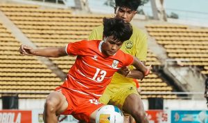 Pemain Timnas Indonesia U-20 dengan jersey merah nomor 13 berebut bola dengan pemain Malaysia .