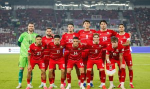 Skuad utama Timnas Indonesia mengenakan jersey merah berdiri dan berpose bersama sebelum pertandingan melawan Bangladesh.