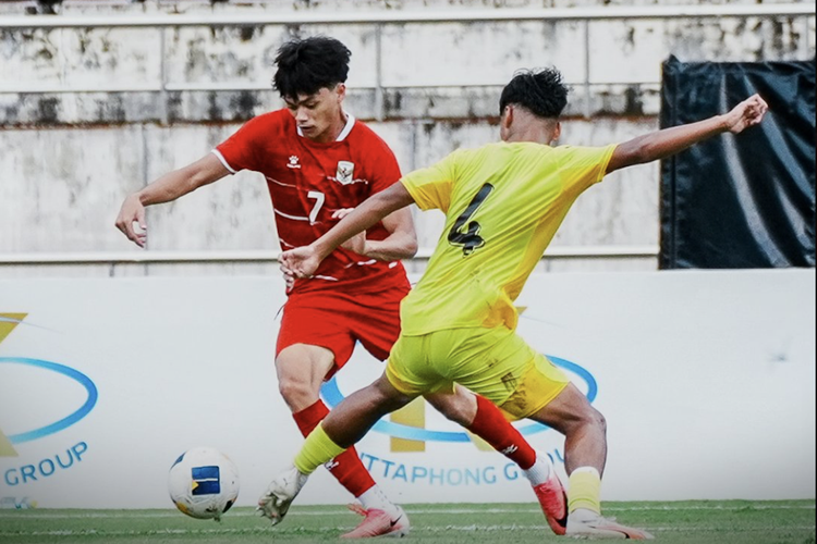 Timnas Indonesia U20 sedang berebut bola dengan pemain Malaysia dalam pertandingan sengit.