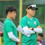 Pelatih Shin Tae-yong mengenakan topi hitam dan baju hijau sedang bersedekap mengamati sesi latihan Timnas.