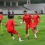 Skuad pemain menjalani sesi latihan Timnas Indonesia dengan seragam latihan merah di lapangan hijau.