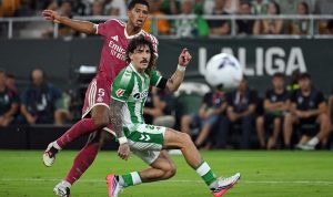 Jude Bellingham dari Real Madrid membayangi pemain Real Betis dalam perebutan bola di pertandingan La Liga.