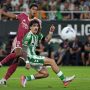 Jude Bellingham dari Real Madrid membayangi pemain Real Betis dalam perebutan bola di pertandingan La Liga.