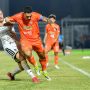 Pemain Persija Jakarta berkostum putih berduel memperebutkan bola dengan pemain lawan di lapangan hijau.
