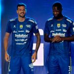 Dua pemain memperagakan jersey Persib Bandung terbaru berwarna biru dengan deretan logo sponsor di bagian depan.