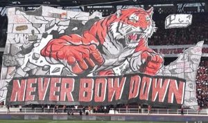 Koreografi 3D Macan Kemayoran dan spanduk Never Bow Down dari The Jakmania di tribun SUGBK