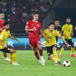 Pemain Timnas Indonesia berseragam merah berusaha merebut bola dari pemain lawan di tengah pertandingan