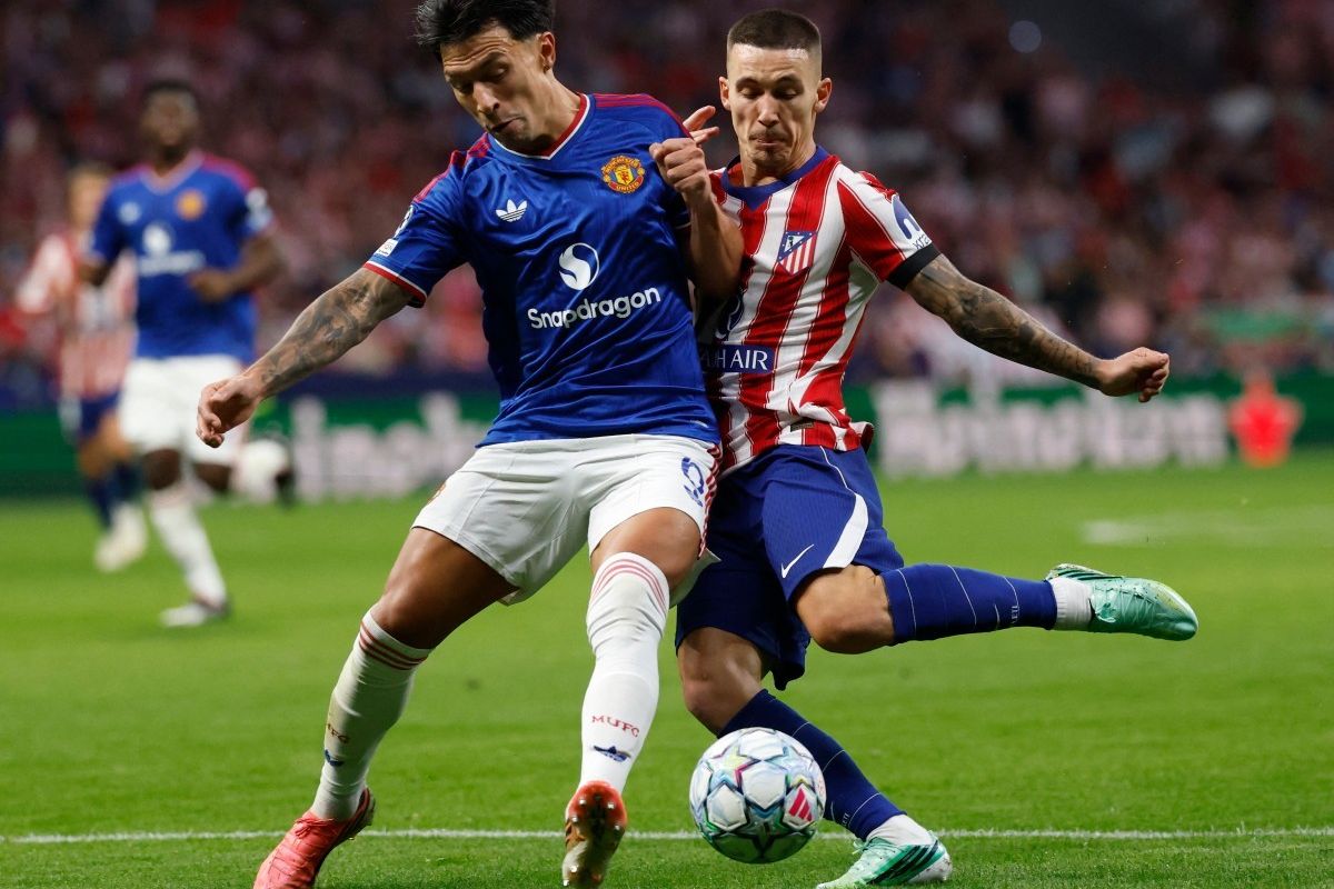 Lisandro Martinez pemain Manchester United sedang berduel memperebutkan bola dengan pemain Atletico Madrid.