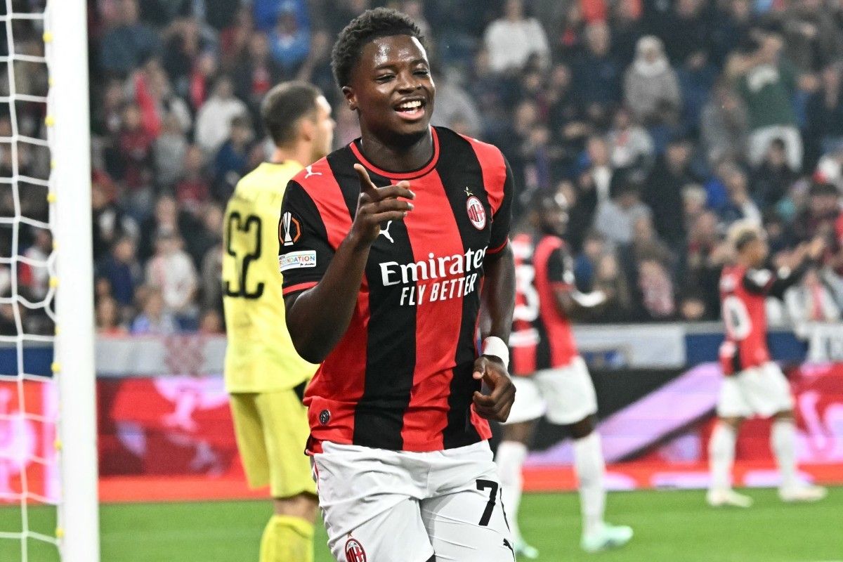 Pemain AC Milan Alphadjo Cisse tersenyum gembira sambil menunjuk ke arah penonton saat merayakan gol melawan Salzburg.