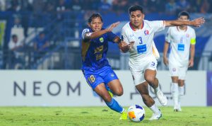 pertandingan-persib-bandung-vs-port-fc.webp Pemain Persib Bandung berduel perebutan bola dengan pemain Port FC di lapangan hijau.