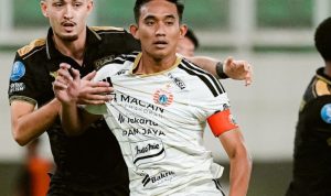 Pemain Persija Jakarta berduel ketat dengan pemain lawan di lapangan.