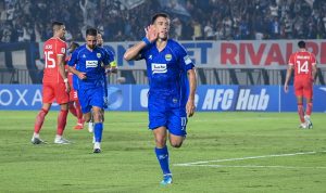 Pemain Persib Bandung Tyronne del Pino merayakan gol dengan meletakkan tangan di telinga saat menghadapi Viettel FC.