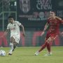 Pemain Persija Jakarta bernomor punggung 17 membendung pergerakan pemain Arema FC di lapangan hijau.