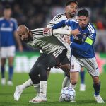 como-vs-manchester-united-duel-pemain.webp Pemain Manchester United berduel memperebutkan bola dengan pemain Como di lapangan.