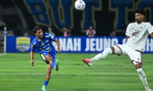Pemain Persib Bandung menendang bola saat berduel melawan pemain lawan dalam pertandingan Liga 1