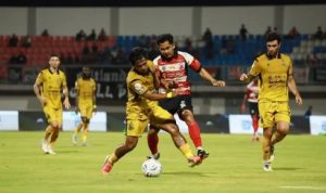 Aksi perebutan bola yang sengit antara pemain Madura United dan Bhayangkara FC dalam laga imbang 3-3.