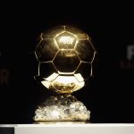 trofi-ballon-dor-2026.webp Trofi bola emas Ballon d'Or dipajang di atas panggung dengan latar belakang gelap