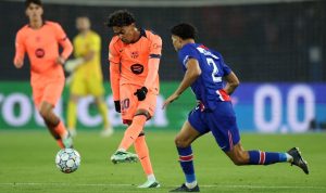 Lamine Yamal dari Barcelona sedang menguasai bola saat dikawal ketat oleh pemain PSG