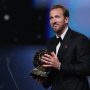 Harry Kane tersenyum bangga sambil memegang trofi Ballon d'Or 2026 di atas panggung penghargaan.
