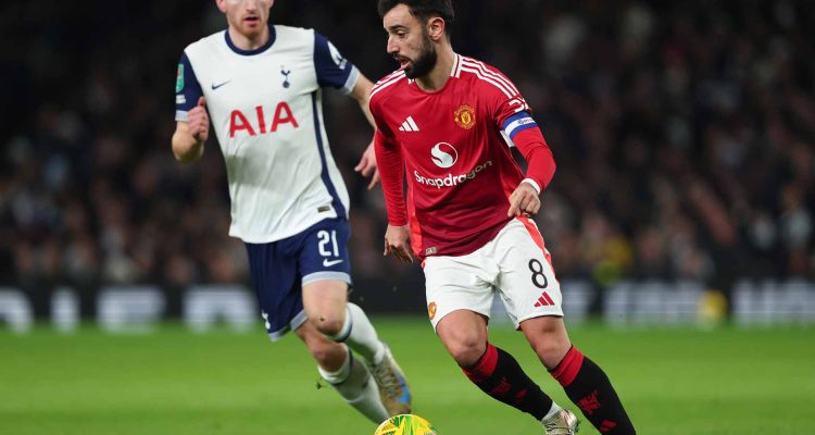 Bruno Fernandes menguasai bola untuk Manchester United saat dibayang-bayangi pemain Tottenham Hotspur