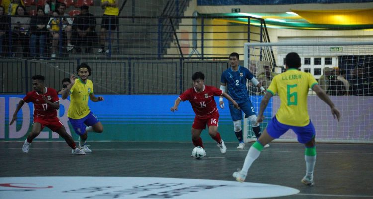 link-streaming-timnas-futsal-indonesia-vs-tanjung-verde.webp Pemain Timnas Futsal Indonesia bernomor punggung 14 menggiring bola di tengah tekanan pemain lawan dalam pertandingan futsal internasional.