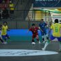 Pemain Timnas Futsal Indonesia bernomor punggung 14 menggiring bola di tengah tekanan pemain lawan dalam pertandingan futsal internasional.