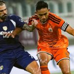 Pemain Persija Jakarta berjersey oranye berebut bola dengan lawan dalam pertandingan Super League