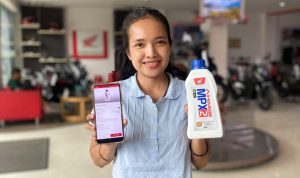 astra-motor-kaltim-1-sosialisasi-qr-code-oli-palsu.webp Perwakilan Astra Motor Kaltim 1 menunjukkan botol AHM Oil MPX2 dan layar smartphone hasil pemindaian QR Code untuk verifikasi keaslian oli.